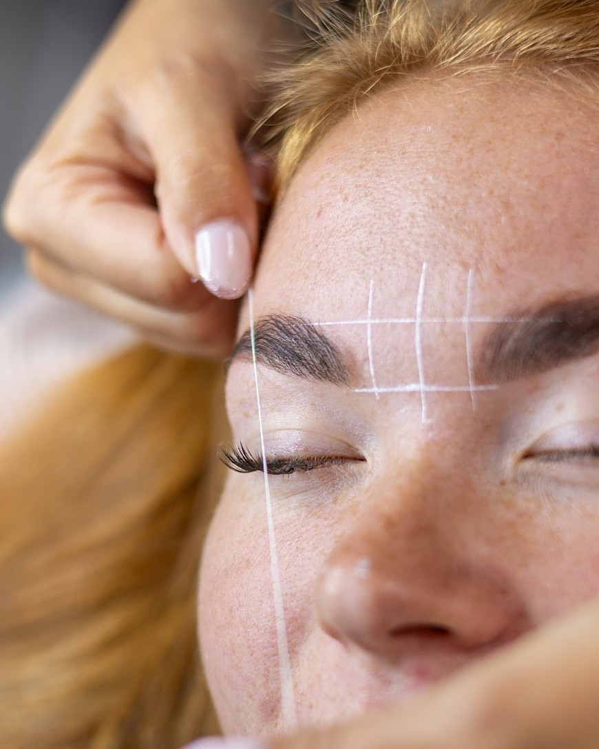 Brow mapping: witte hulplijnen rond de wenkbrauwen van een klant
